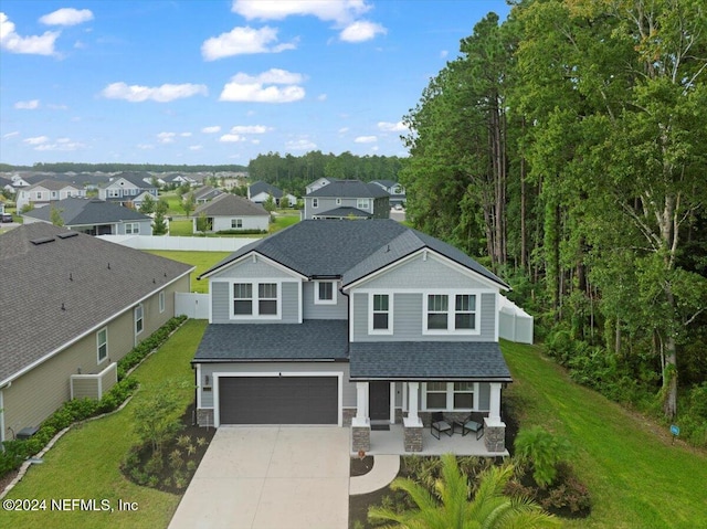 view of front of house with a front lawn, a garage, and a porch