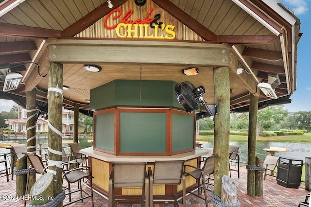 view of patio featuring an outdoor bar and a water view