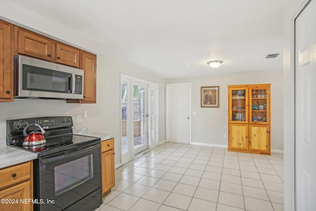 kitchen featuring light tile patterned floors and electric range