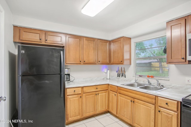 kitchen with black appliances, sink, and light tile patterned floors