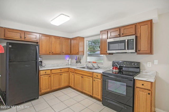 kitchen featuring black appliances, sink, and light tile patterned floors