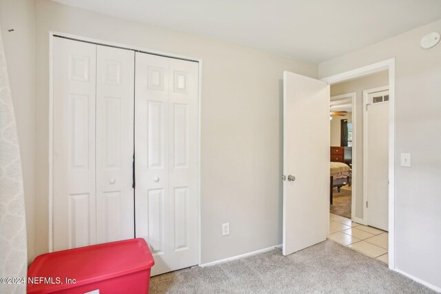 unfurnished bedroom with a closet and light carpet