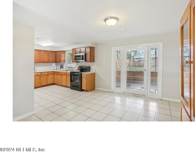 kitchen featuring light tile patterned floors and black range with electric stovetop