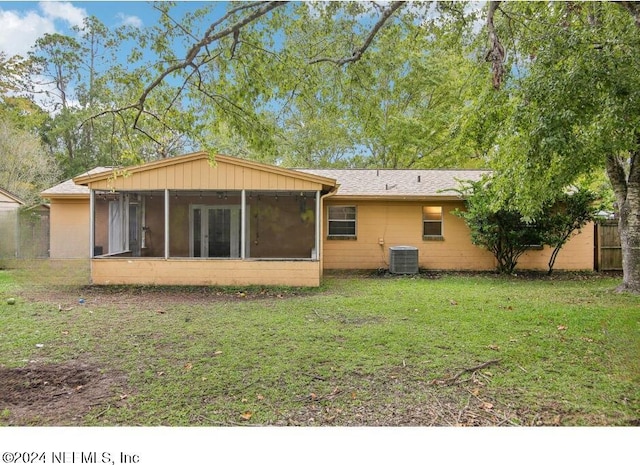 back of property with a sunroom and a yard