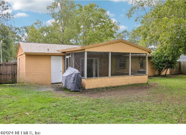 back of house with a sunroom and a yard