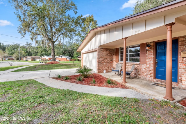 view of property exterior featuring a garage, a yard, and covered porch