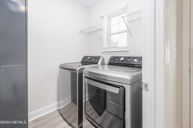 laundry area featuring separate washer and dryer and light wood-type flooring