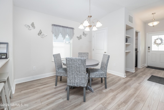 dining room featuring light wood-type flooring and an inviting chandelier