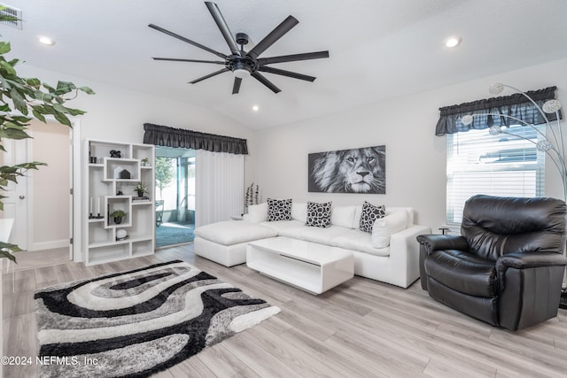 living room with ceiling fan, lofted ceiling, a healthy amount of sunlight, and light hardwood / wood-style flooring