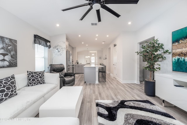 living room with light hardwood / wood-style floors and ceiling fan