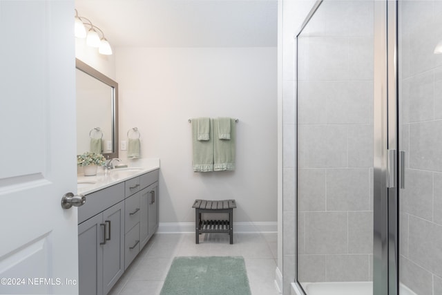 bathroom with an enclosed shower, vanity, and tile patterned floors