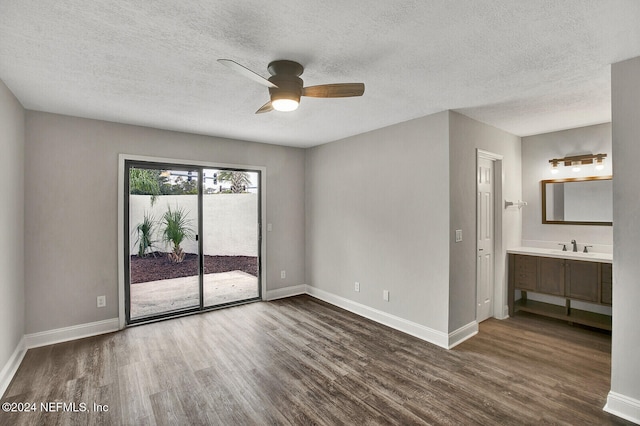 spare room with dark wood-type flooring, ceiling fan, and a textured ceiling