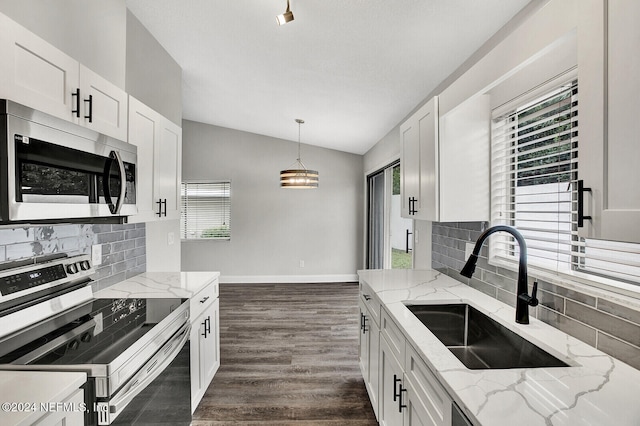 kitchen with white cabinetry, sink, appliances with stainless steel finishes, hanging light fixtures, and decorative backsplash