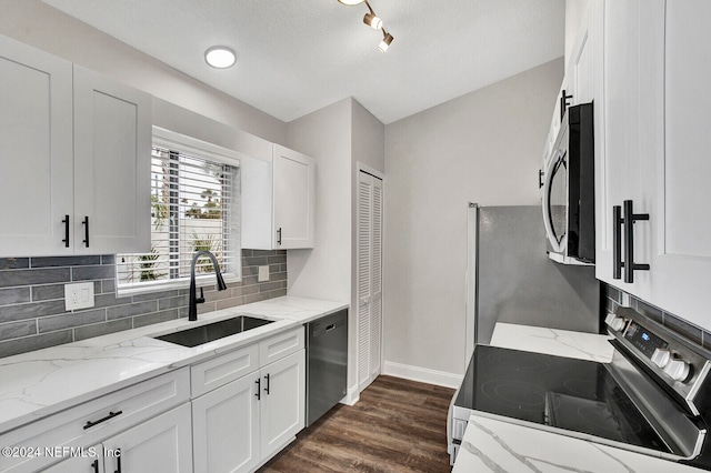 kitchen featuring white cabinets, stainless steel appliances, sink, and light stone counters