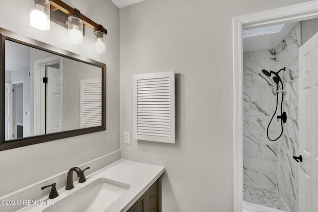 bathroom with tiled shower and vanity