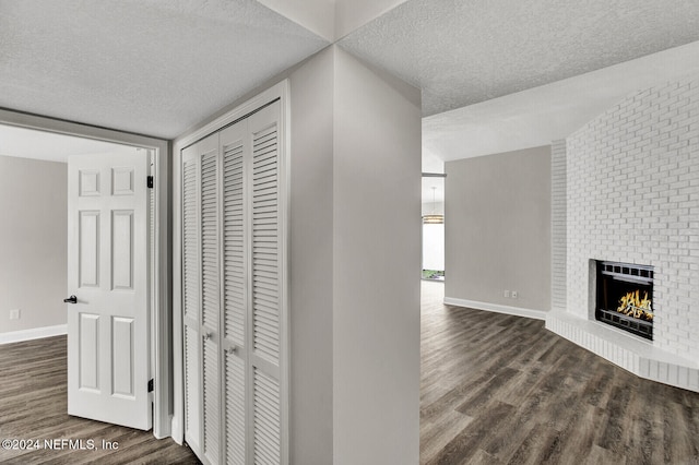 hall with dark hardwood / wood-style flooring and a textured ceiling