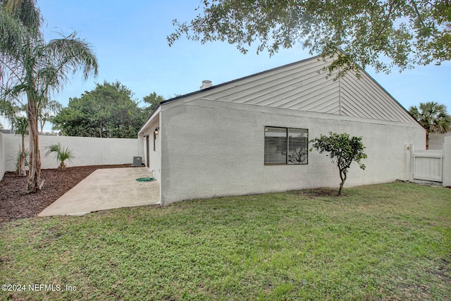 view of home's exterior with a patio and a lawn