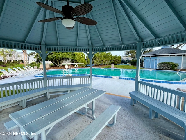 view of pool with ceiling fan, a patio, a gazebo, and an outdoor structure