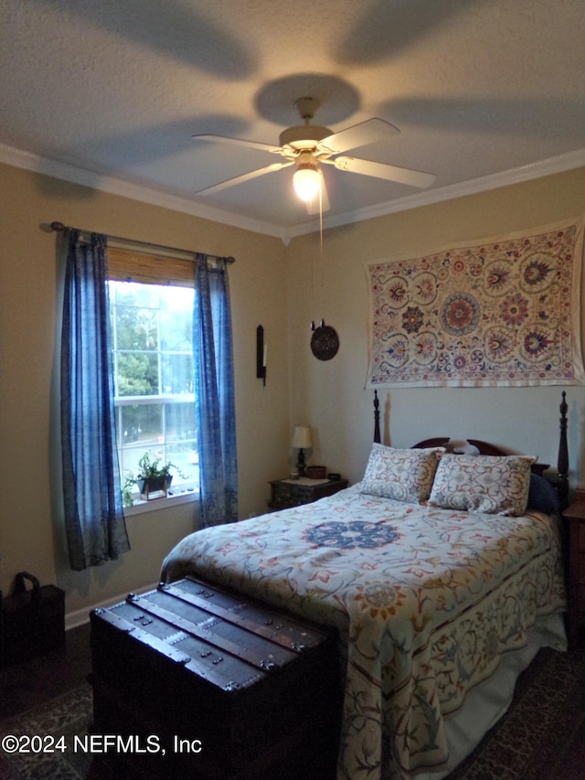 bedroom with ceiling fan, a textured ceiling, and crown molding