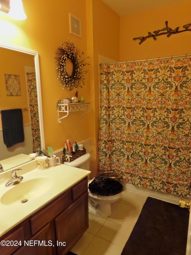 bathroom featuring vanity, tile patterned floors, and toilet