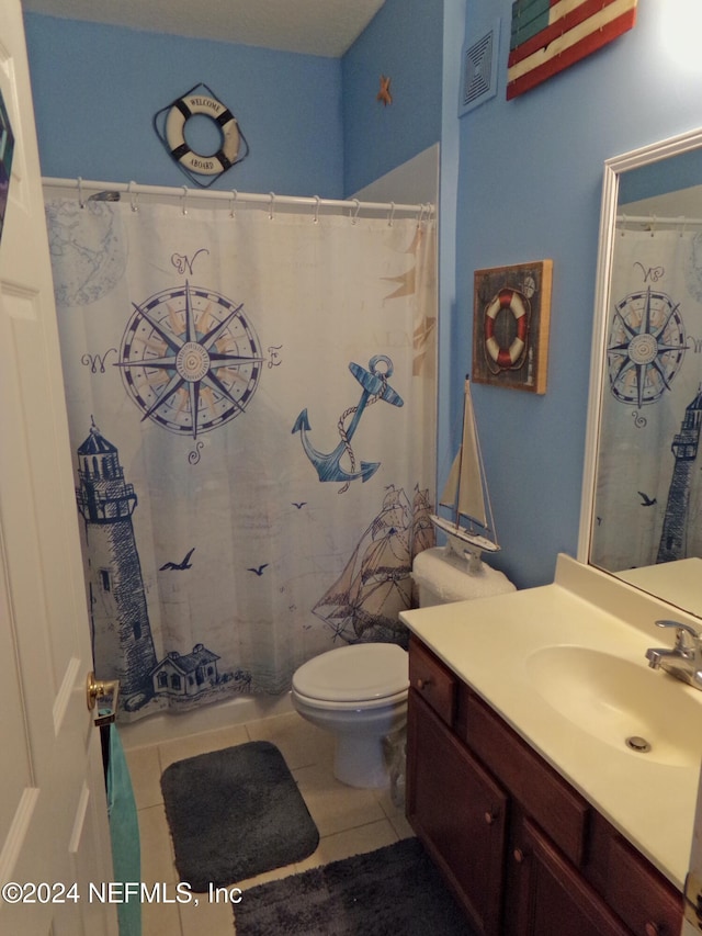 bathroom with toilet, vanity, and tile patterned floors