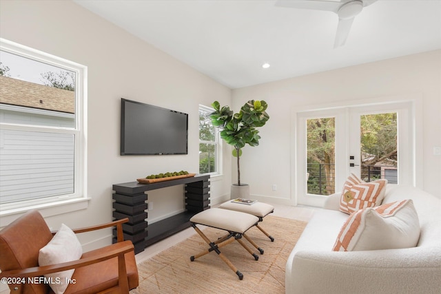 living room featuring ceiling fan, french doors, and light hardwood / wood-style flooring