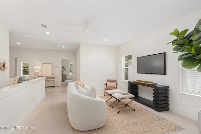 living room with light wood-type flooring and ceiling fan