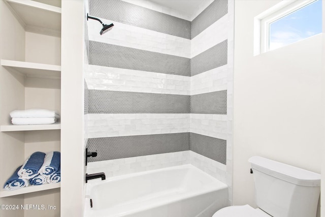 bathroom with toilet and tiled shower / bath