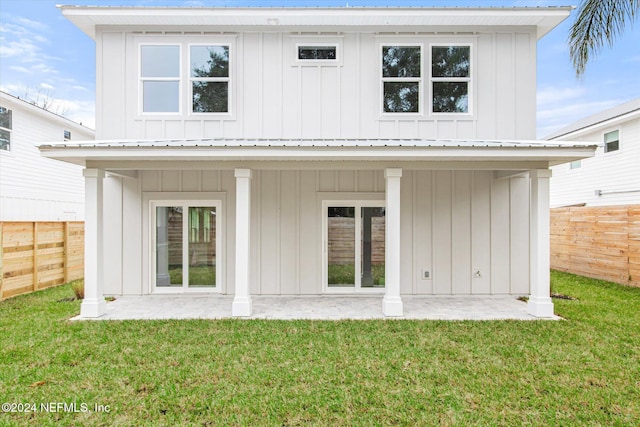 rear view of property featuring a lawn and a patio