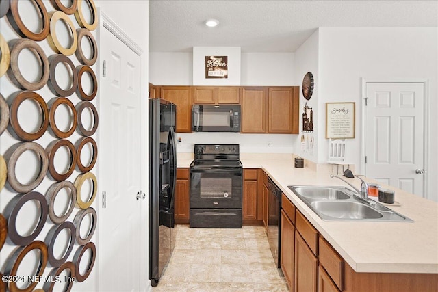 kitchen featuring a textured ceiling, kitchen peninsula, black appliances, and sink