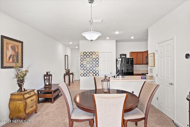 carpeted dining room with sink