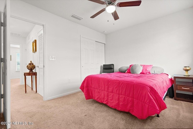 carpeted bedroom featuring ceiling fan and a closet