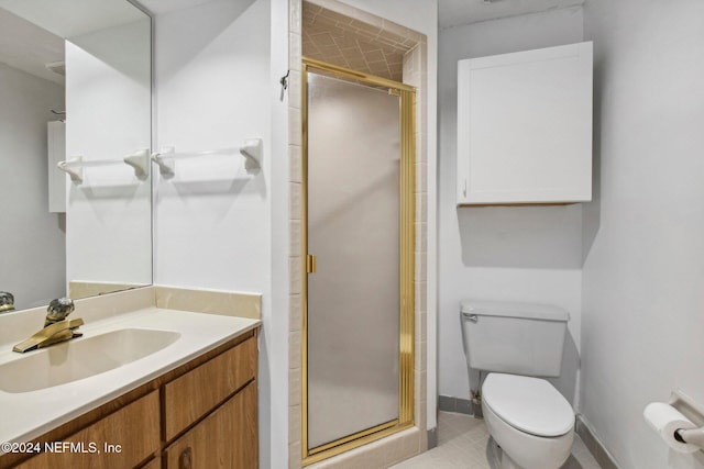 bathroom featuring tile patterned floors, vanity, toilet, and a shower with door