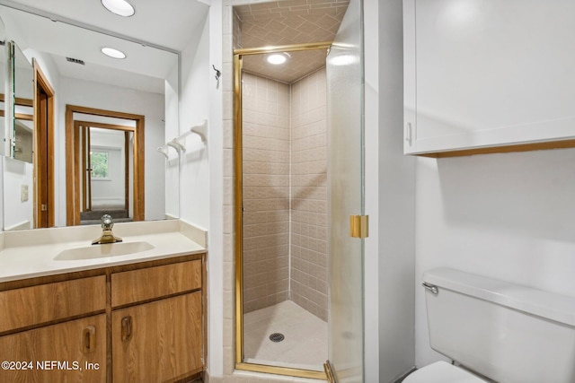 bathroom with vanity, toilet, and a shower with shower door