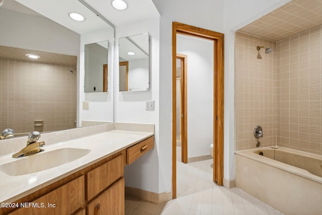 full bathroom featuring tile patterned floors, vanity, tiled shower / bath combo, and toilet