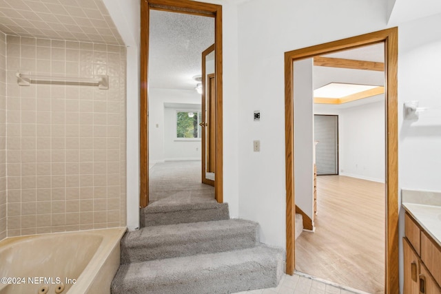 stairway with a textured ceiling and hardwood / wood-style flooring