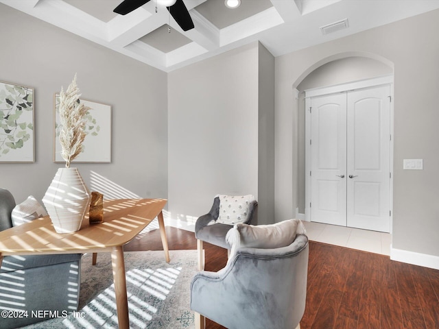 living area with beamed ceiling, dark hardwood / wood-style floors, ceiling fan, and coffered ceiling