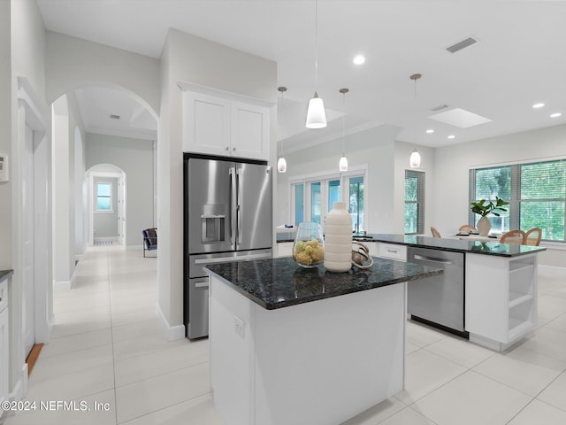 kitchen with white cabinetry, appliances with stainless steel finishes, a healthy amount of sunlight, and a center island