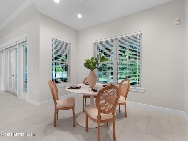 tiled dining space with plenty of natural light and crown molding