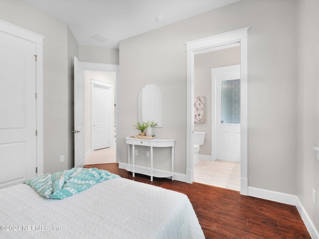 bedroom featuring connected bathroom and wood-type flooring