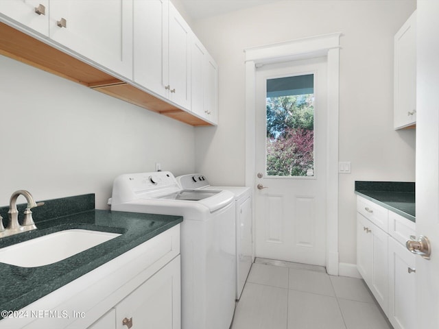 laundry area with cabinets, sink, washer and dryer, and light tile patterned floors