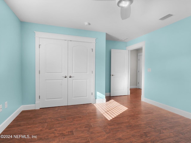 unfurnished bedroom featuring ceiling fan, dark hardwood / wood-style floors, and a closet