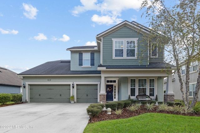 view of front facade featuring a front yard, a garage, and covered porch