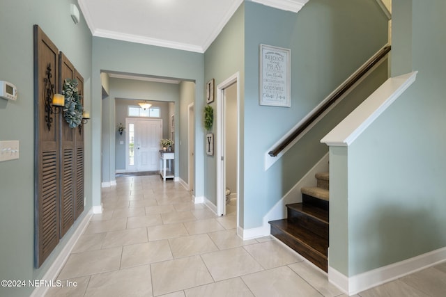 tiled foyer entrance with crown molding