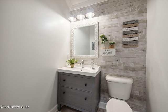 bathroom with toilet, vanity, and crown molding