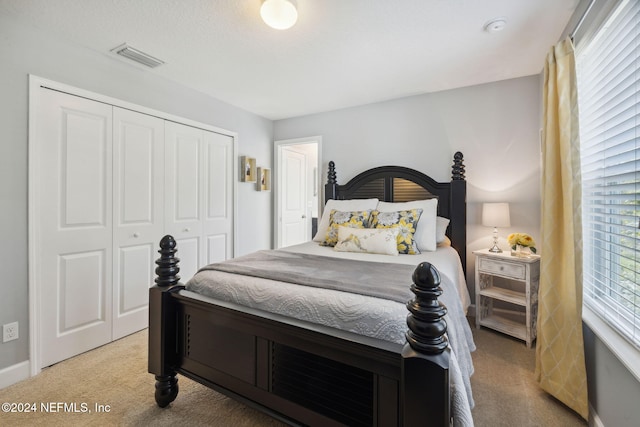 bedroom featuring a closet and light colored carpet