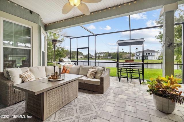 view of patio / terrace with an outdoor hangout area, a water view, a lanai, and ceiling fan