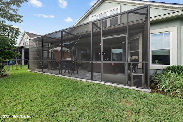 back of house featuring a lanai, a patio, and a yard