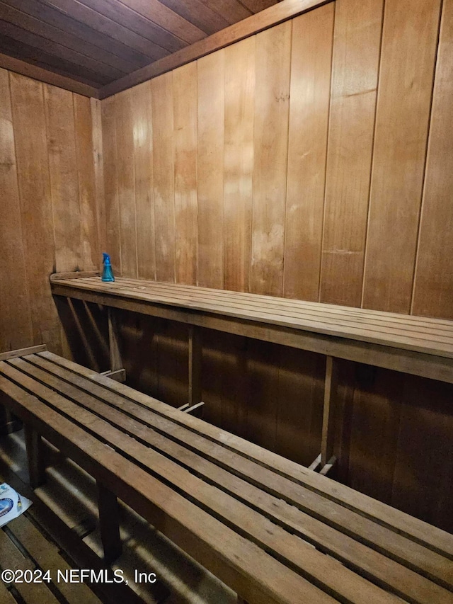 view of sauna featuring wood ceiling and wooden walls