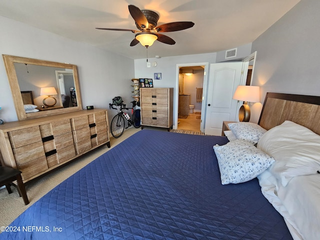 carpeted bedroom with ensuite bathroom and ceiling fan